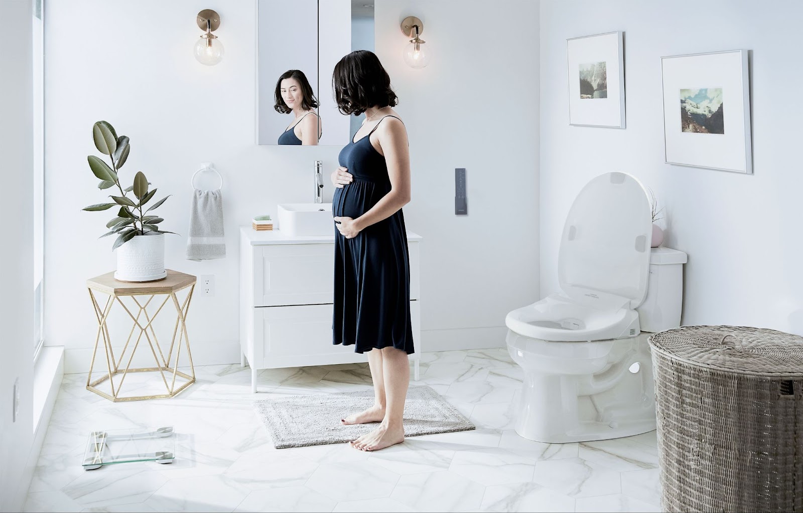 A pregnant woman next to a bidet.