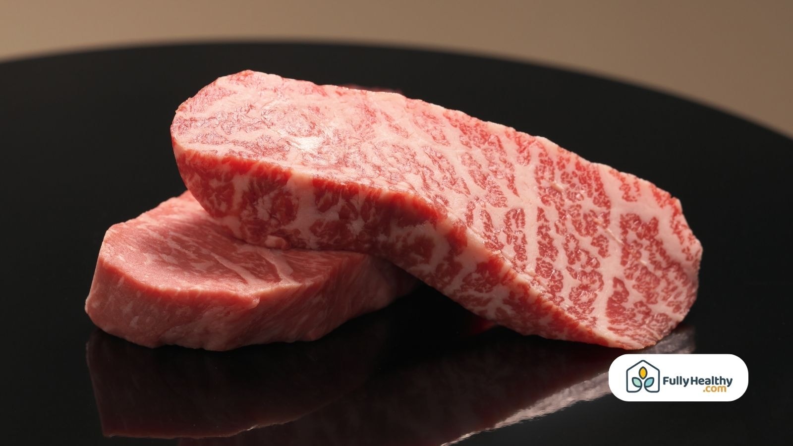 Raw wagyu beef steaks with heavy marbling on black surface