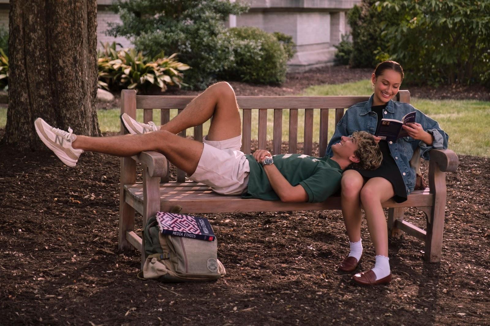 A person and person lying on a bench

Description automatically generated