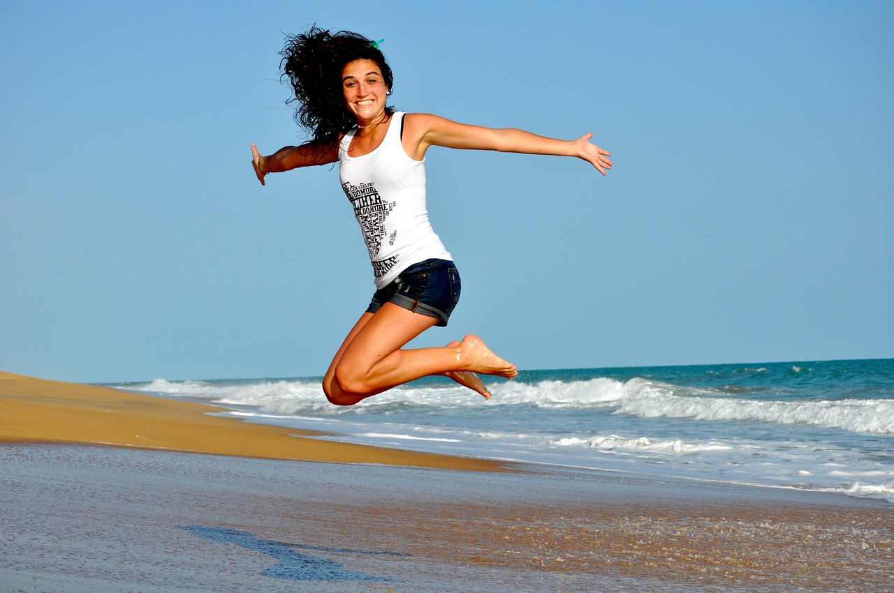 A happy woman jumping on a beach