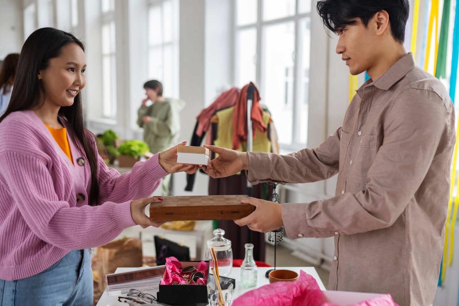 Woman giving a gift box, depicting consumer behavior in gift purchasing.