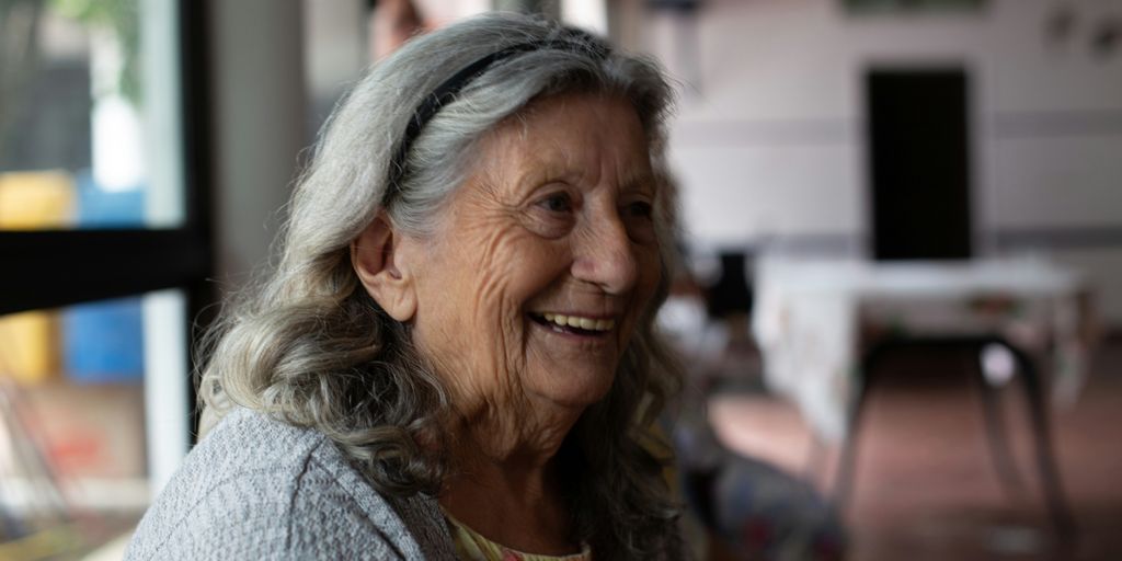 smiling woman in gray cardigan