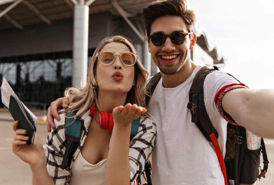 Mladý a veselý pár si dělá selfie na letišti, jelikož zrovna míří na letní dovolenou v Řecku, na kterou si sjednali výhodně cestovní pojištění s 50% slevou