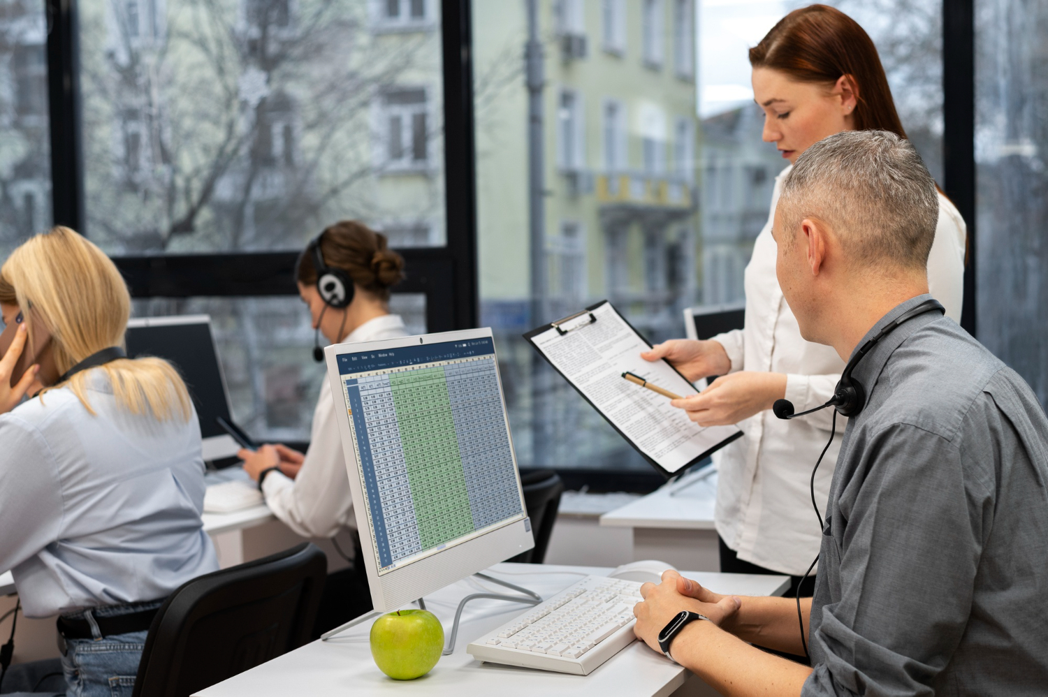 An ergonomics consultant reviewing data with a colleague in a modern office setting.