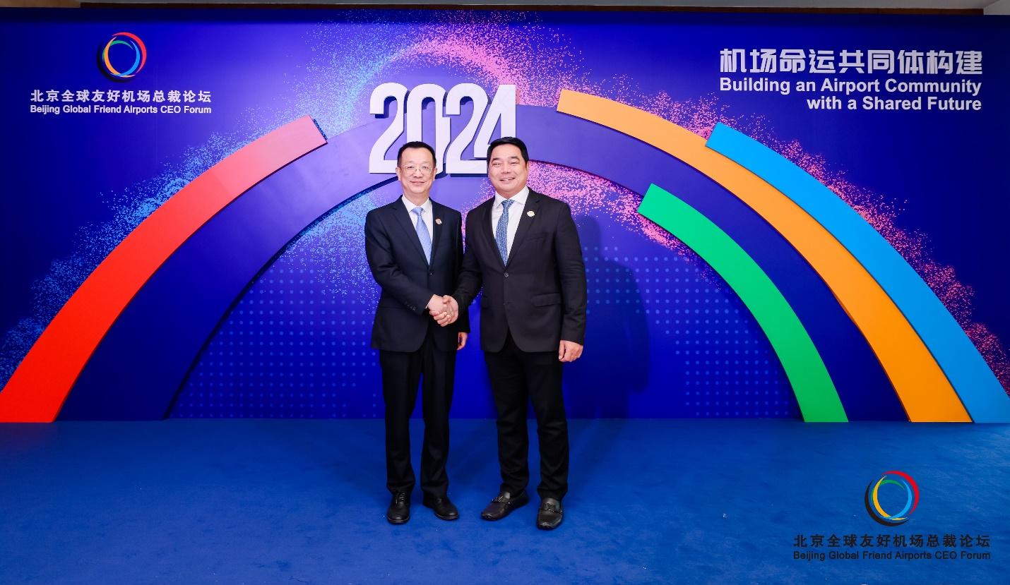 Two men in suits shaking hands in front of a blue wall with colorful linesDescription automatically generated