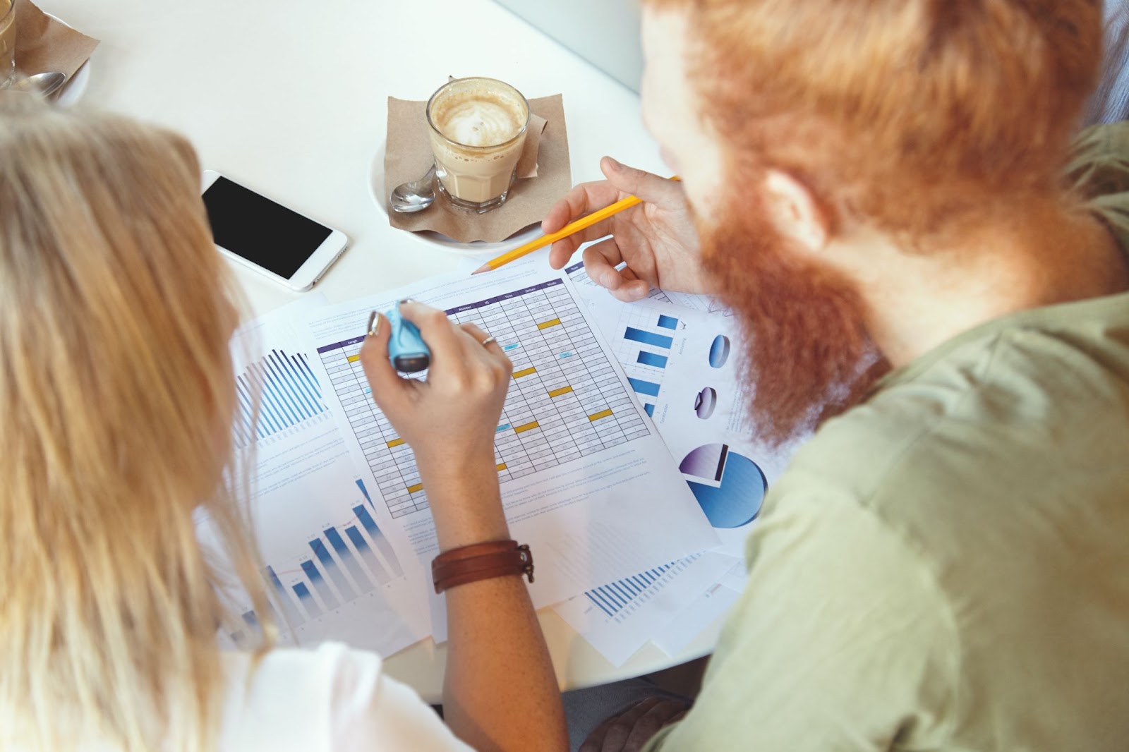 man and woman looking at charts on papers 