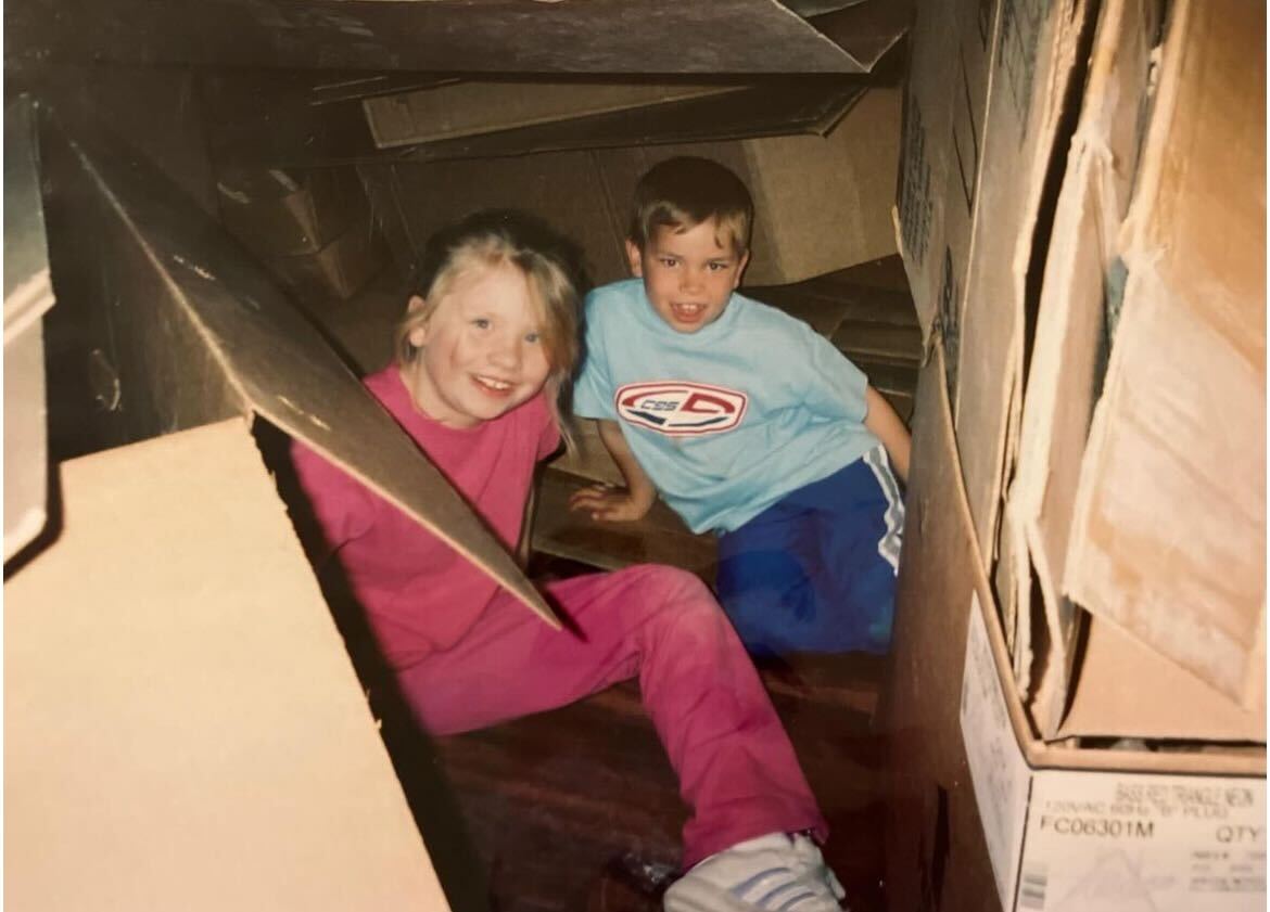 Two children help unpack boxes for a restaurant bar opening.