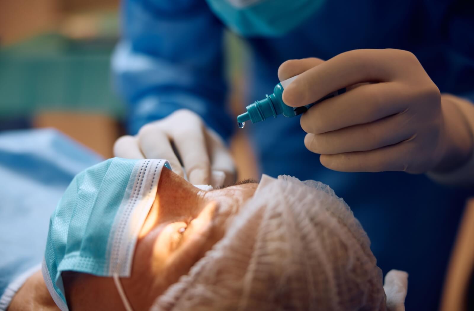 Close-up of a patient as their ophthalmologist applies numbing eye drops before ICL surgery.