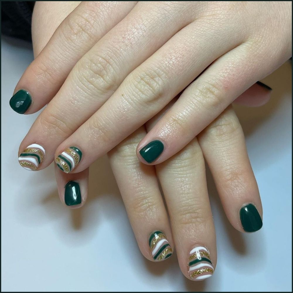 Close up of hands with Christmas Green Nails having  Christmas Short Nails with Swirls