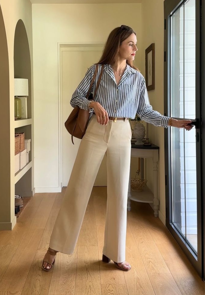 Wanita dengan trouser cream dan striped shirt biru.