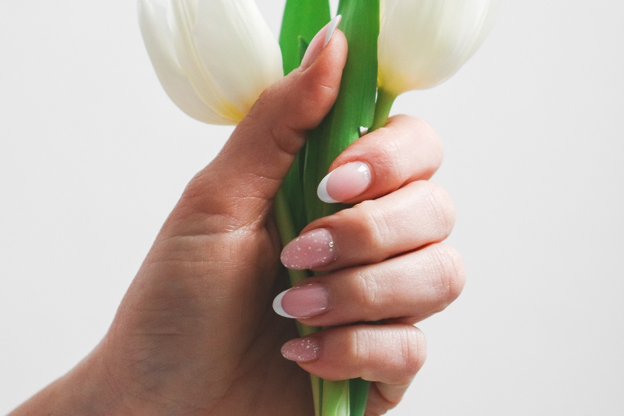 Minimalist floral tips add subtle, nature-inspired charm to French nail tip design.