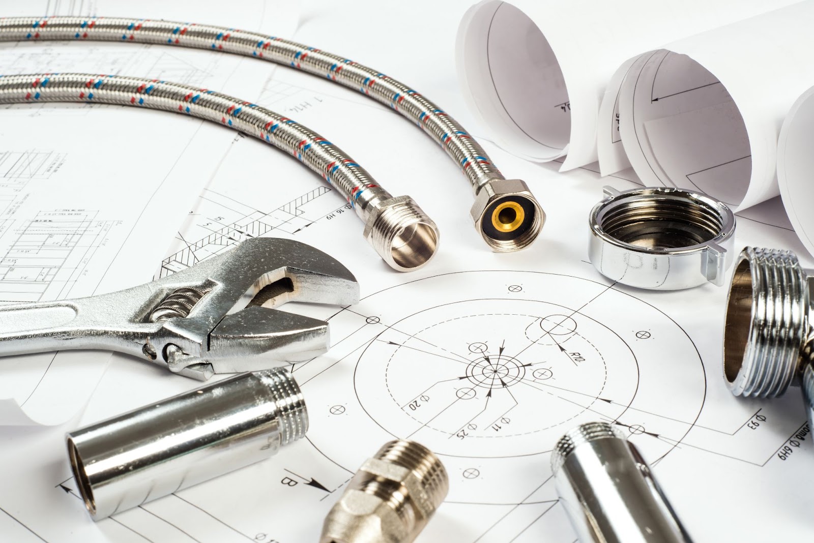 Plumbing components are neatly arranged around technical drawings on the table.