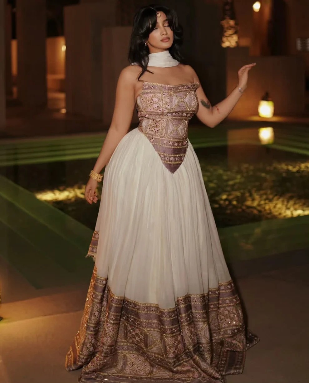 Woman in strapless white Habesha dress with gold thread embroidery