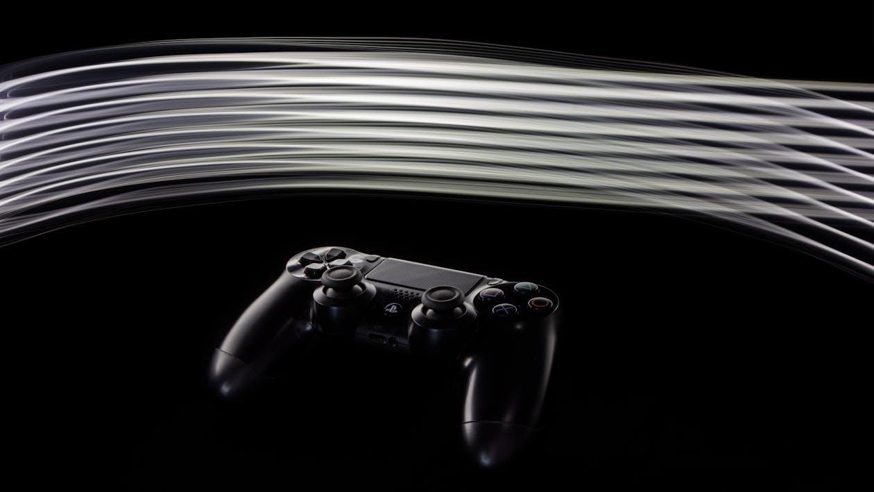 Free Close-up of a PS4 controller with dynamic light streaks on a black background. Stock Photo