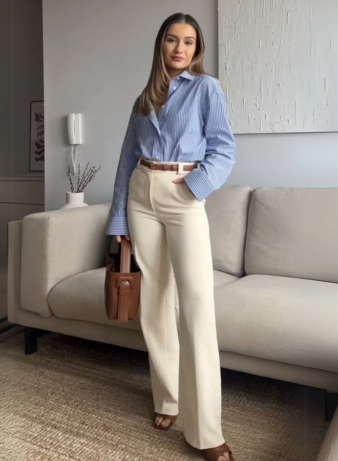 Wanita dengan baju biru dan celana beige.
