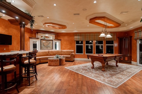 Basement entertainment space witha. pool table, bard and seating area.