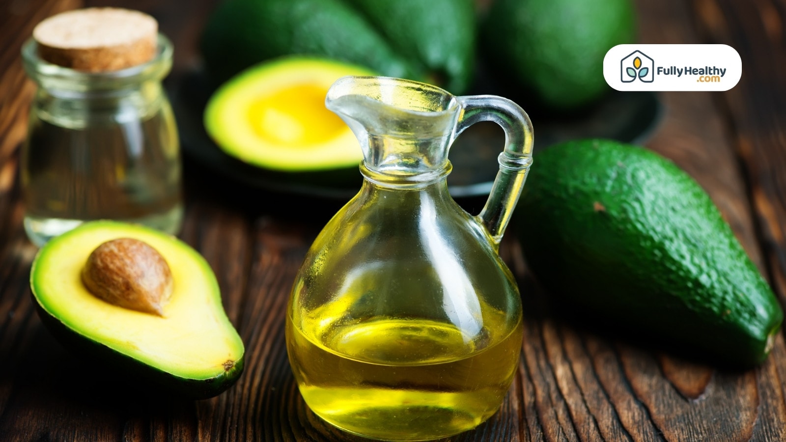 Glass jug of avocado oil with fresh avocados and lemon halves