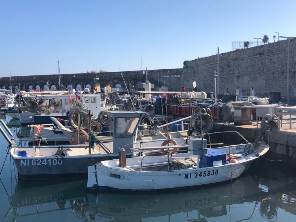 Boats in a harbor with a stone wall and a stone wall

Description automatically generated