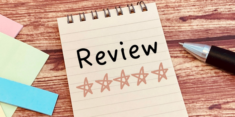 「Review」という文字と5つ星評価が書かれたノートとペン