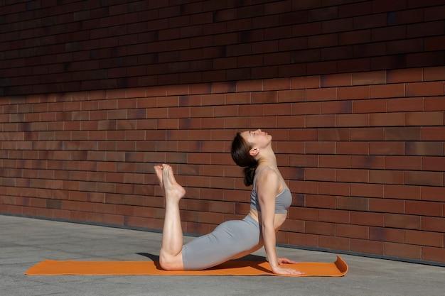 Full shot woman doing yoga on mat