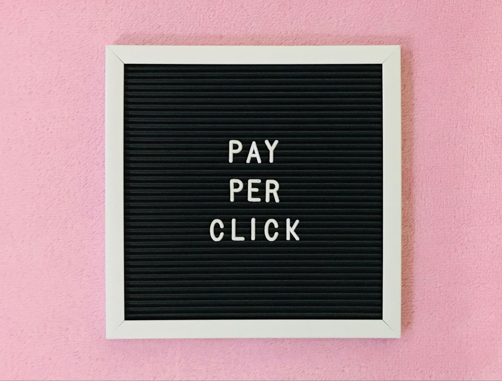 Words “Pay Per Click” on a wooden letter board.