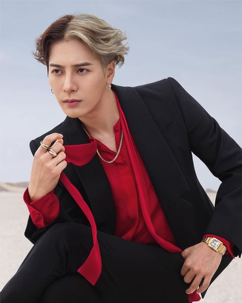 This  contain an image of  Jackson in a red shirt and black jacket sitting on the ground with her hand on her lapel