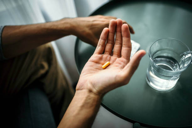 A fit man holding a berberine supplement, showcasing its role in supporting weight loss and overall health.