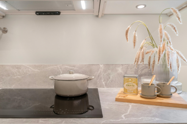 top high end appliances for your kitchen remodel induction cooktop with pot and solid slab backsplash custom built michigan