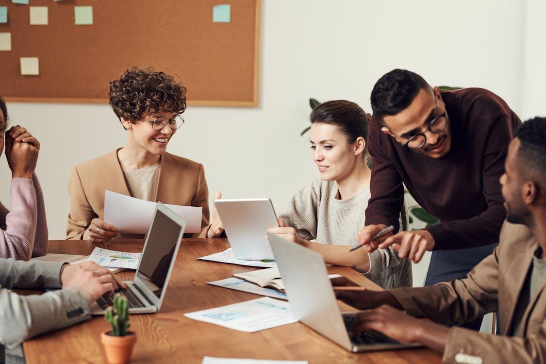 Free A diverse group of professionals engaged in a collaborative office meeting, sharing ideas and discussing projects. Stock Photo