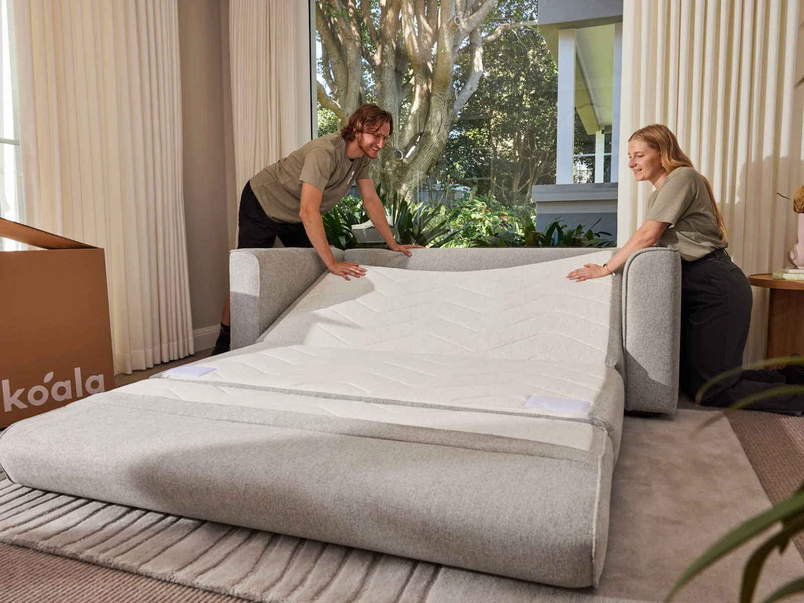 Koala employees handling a sofa bed delivery