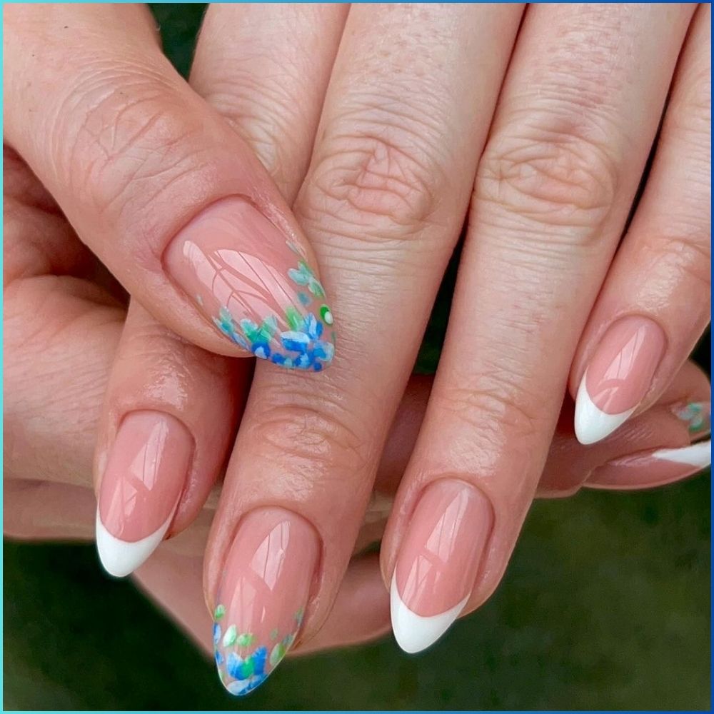 Close up of hands with flowered designed blue nails having Flower Petal Tips