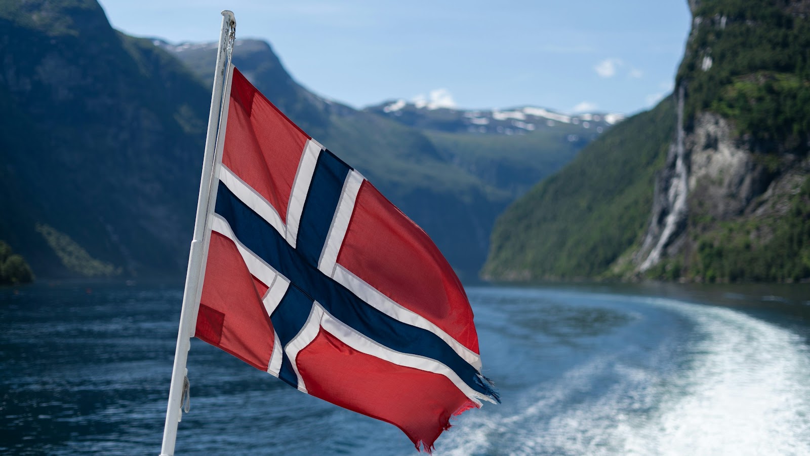 A flag flying from a boat in a body of water