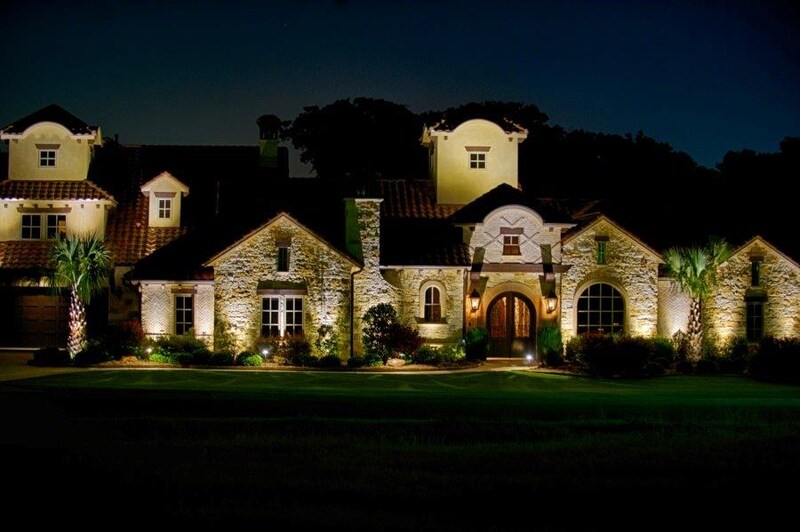 A large home illuminated with outdoor lighting.