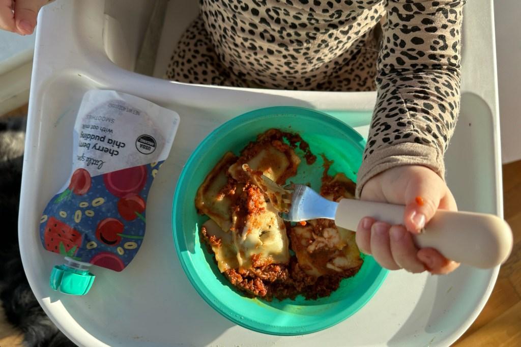 A child eating food while sitting in a chair