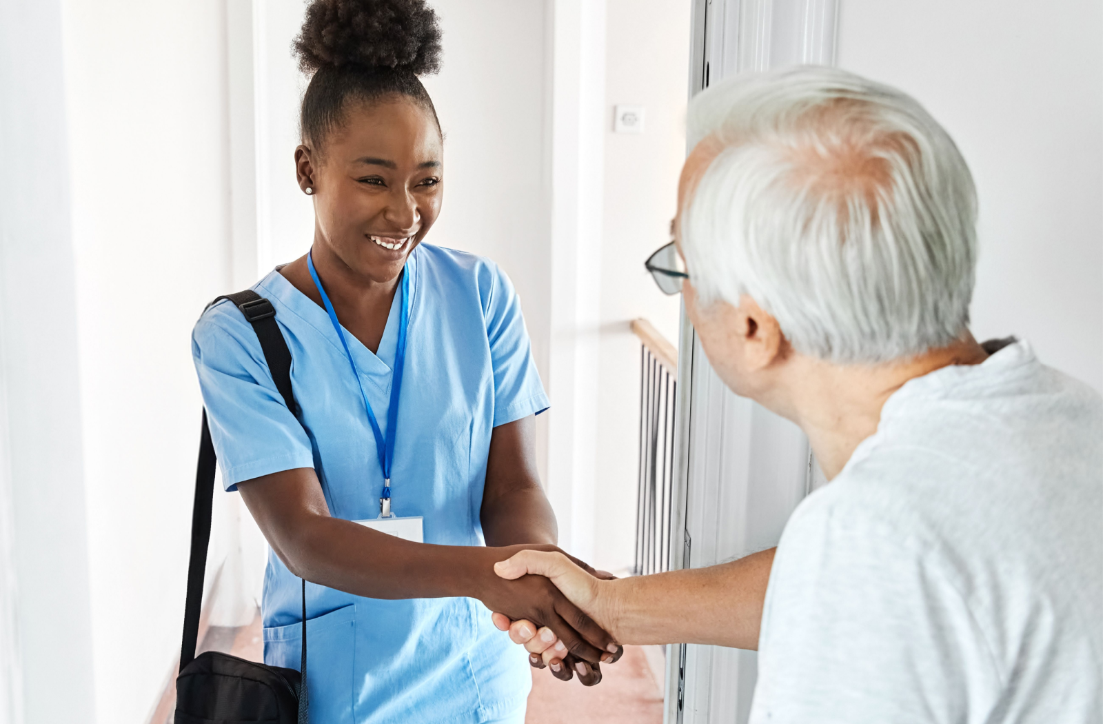 A happy memory care nurse greets a senior resident for the first time.