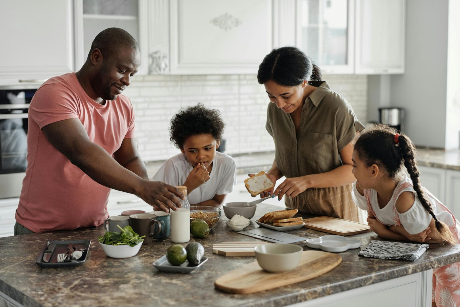 A family of four preparing breakfast in the kitchen