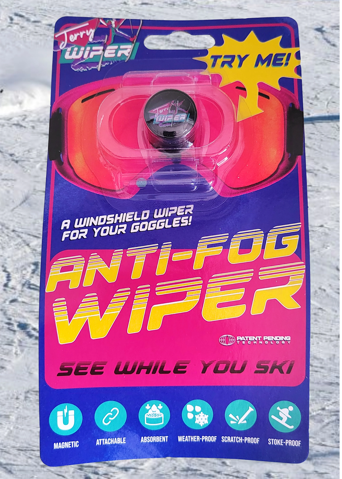 much like the envelope has a retro feel to it. it is colored blue and pink, It has a picture of snow goggles on the package with the jerry wiper over the goggles it also has the words that says a windshield wi[er for your goggles, Anti-Fog Wiper, See while you ski, Magnetic, Attachable, absorbent, weather-proof, scratch-proof, stoke-proof