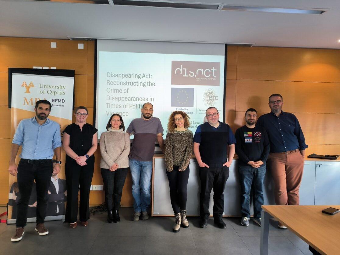A group of people standing in front of a screen

Description automatically generated