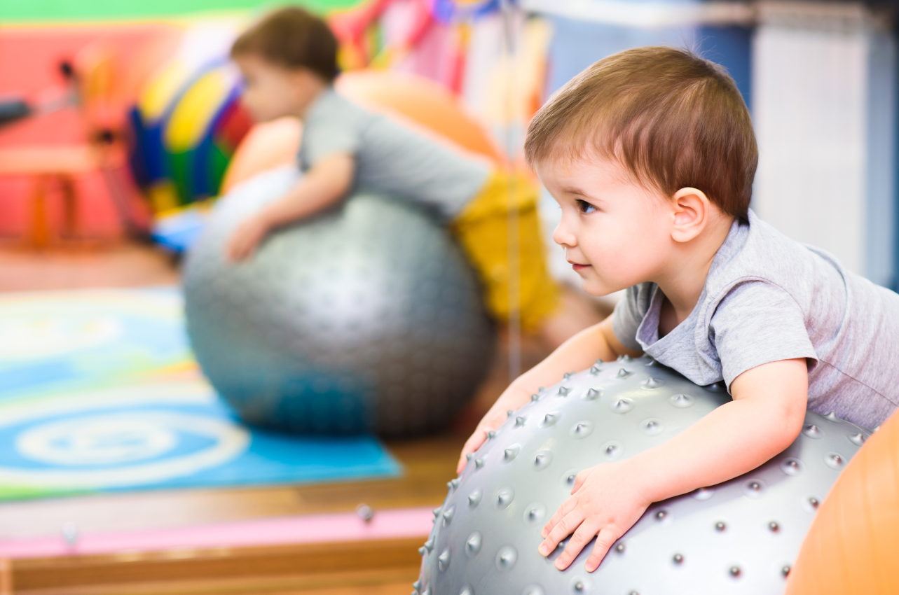 Close up of toddler on a gray exercising ball // Healthier Baby Today