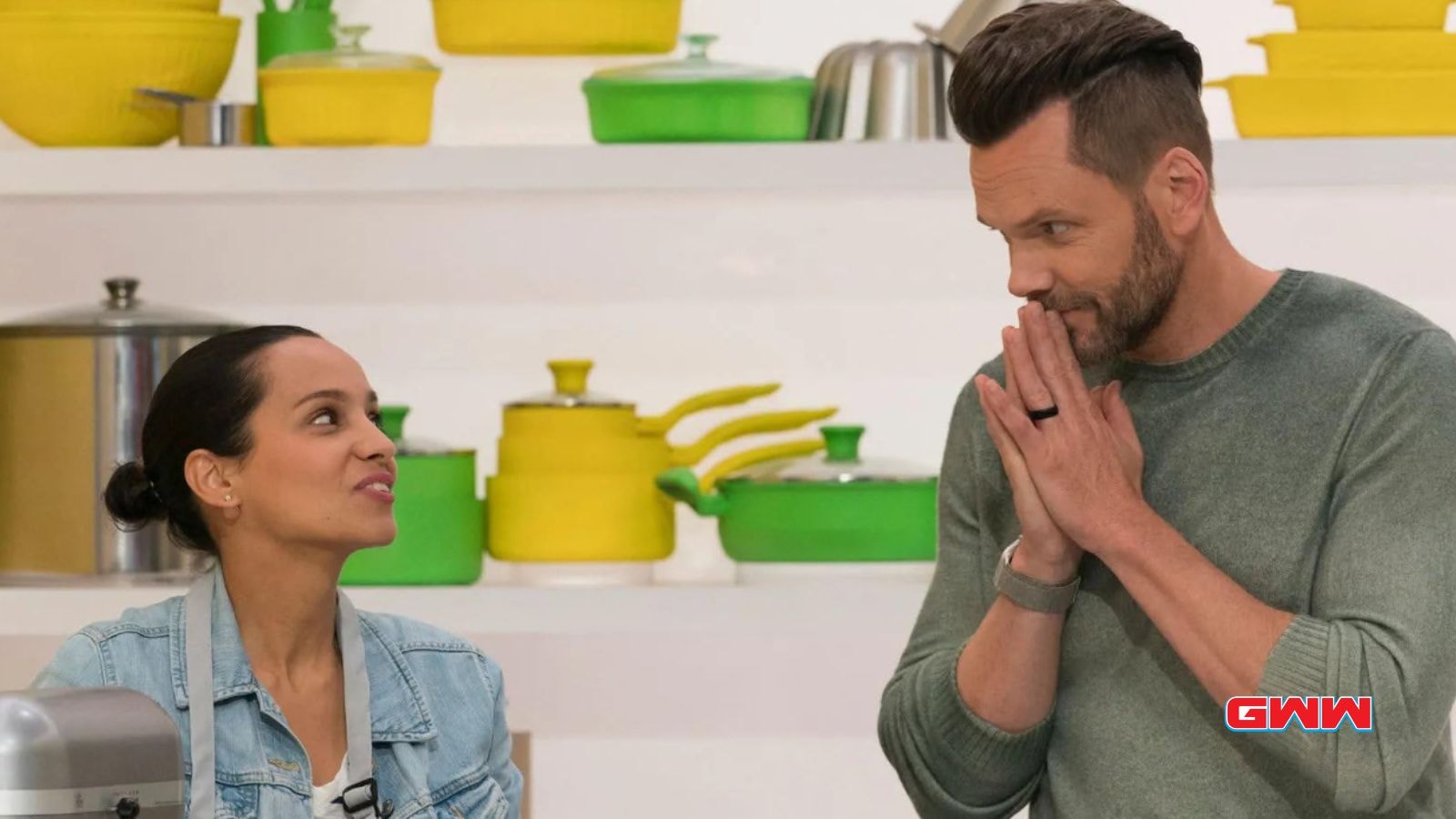 Host Joel McHale interacting with a contestant during a Crime Scene Kitchen challenge.