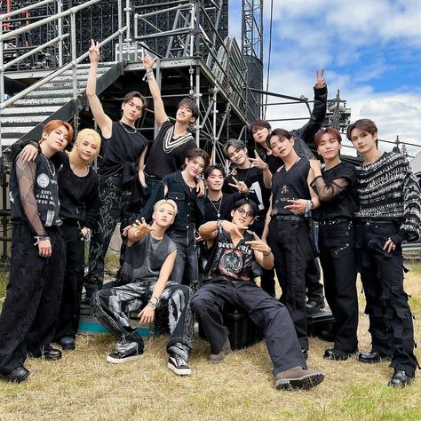 This may contain: a group of young men standing next to each other in front of a metal structure