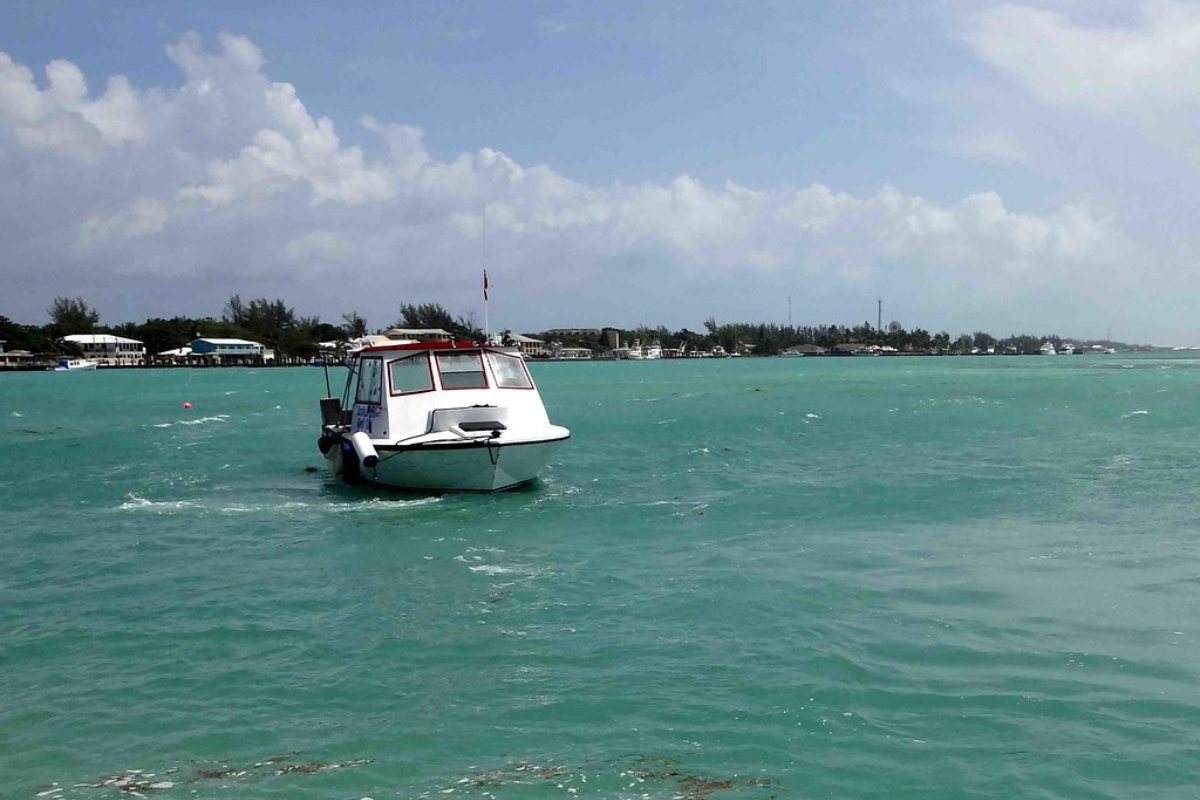 White colored boat is sailing in the clean and clear water