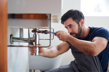 hidden bathroom remodel costs to keep in mind plumber fixing sink pipes custom built michigan