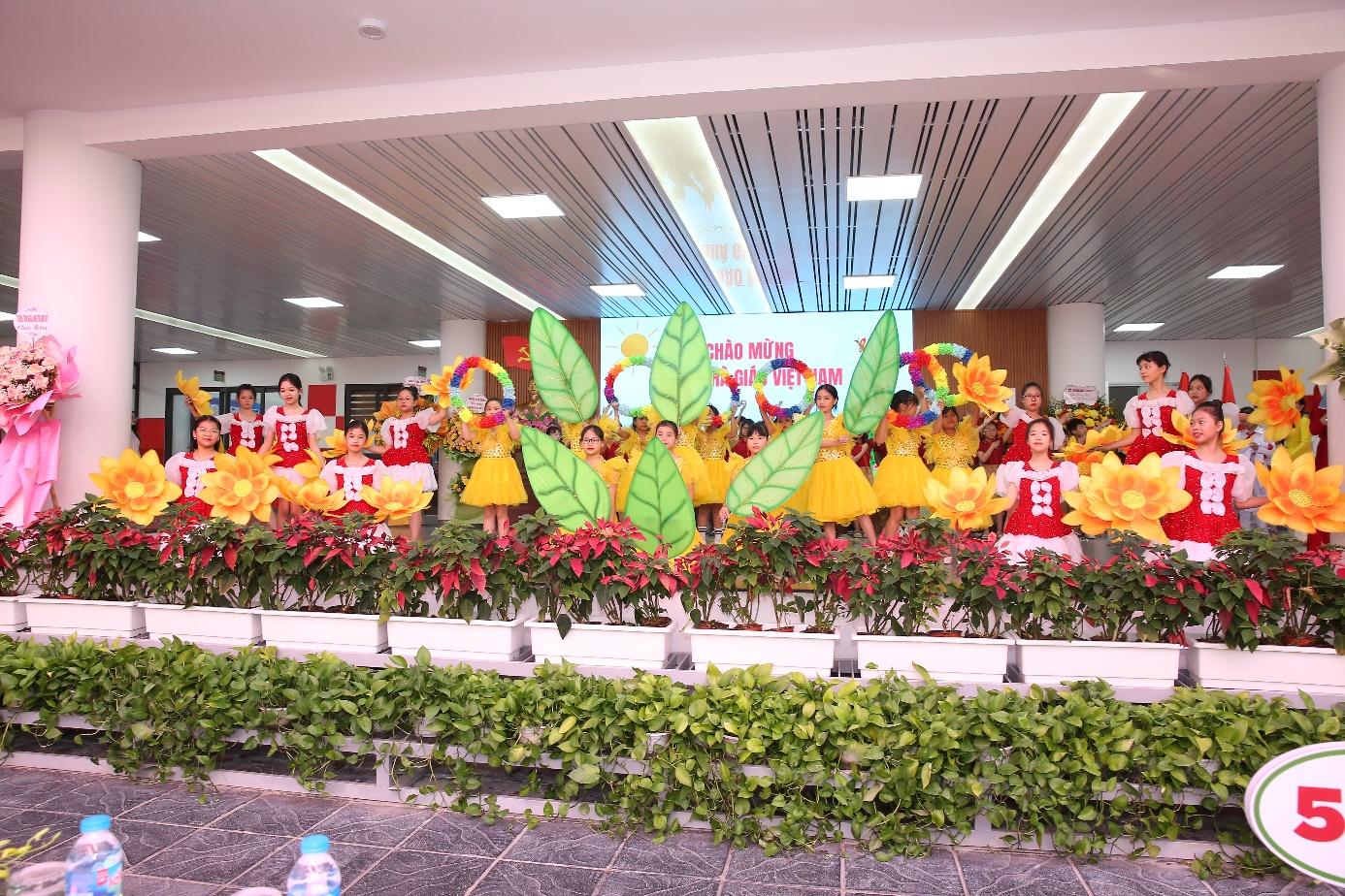 A group of children in clothing in a room with plants

Description automatically generated