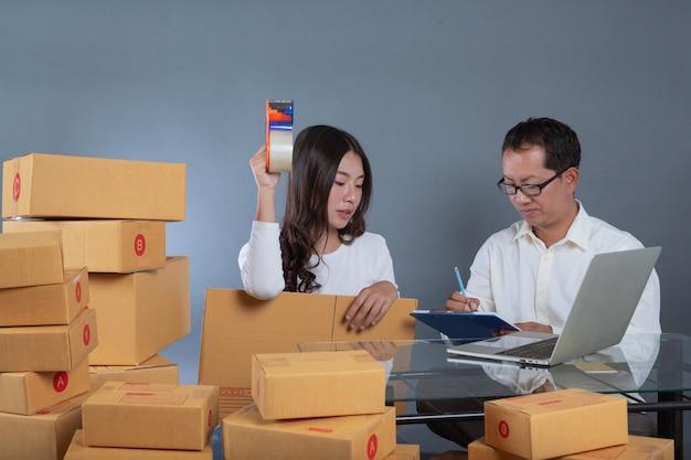 Men and women are helping to pack the boxes.