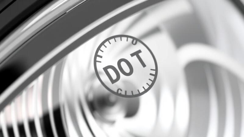 Close-up of a DOT certification stamp on a headlight casing
