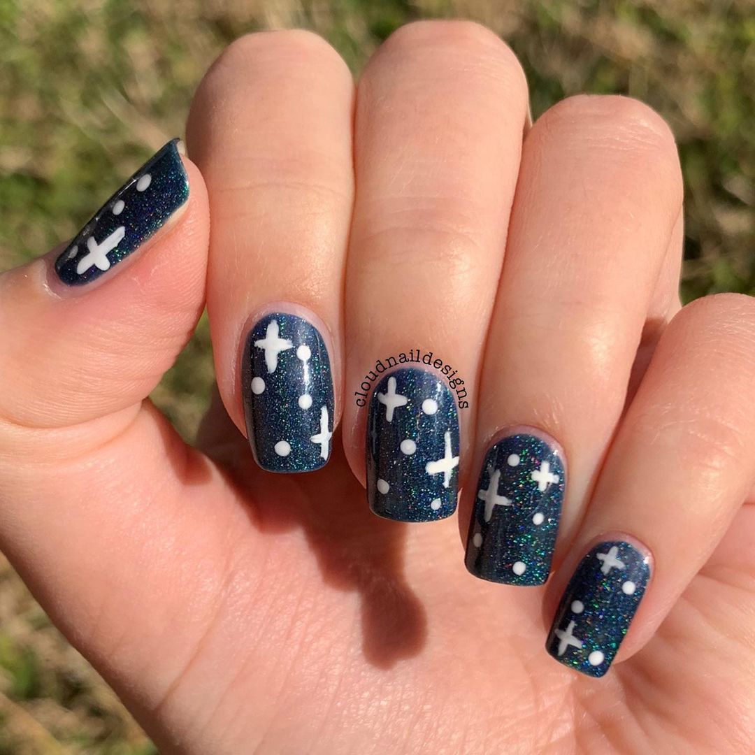 Close-up of a person's hands with black nails having Starry Night Designs