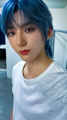 This contains: Hwon kingdom photo with a blue hair and his putting on a ash color shirt 