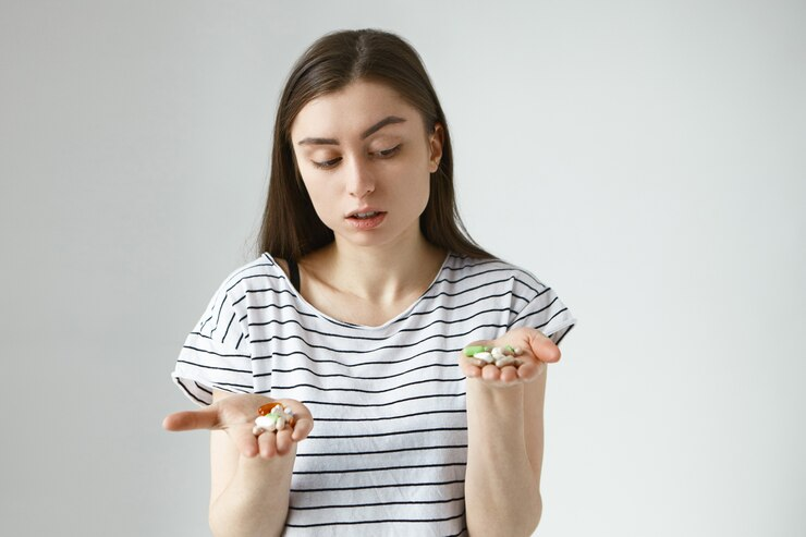 A woman holding the Methylfolate and Folic Acid supplements in both hands.