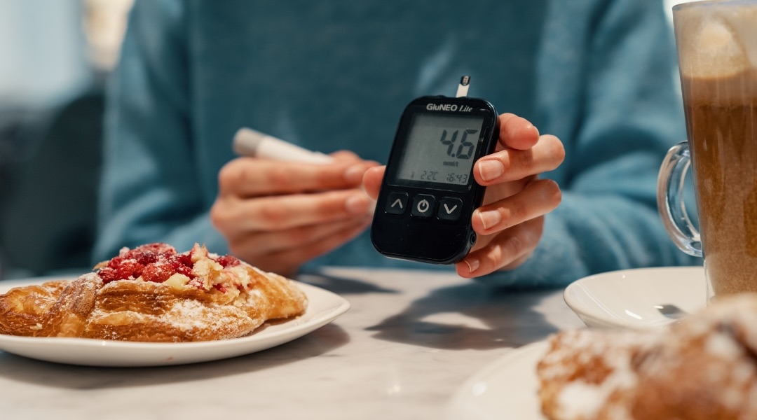 Diabetic woman measuring a normal blood sugar level, preparing for a meal.